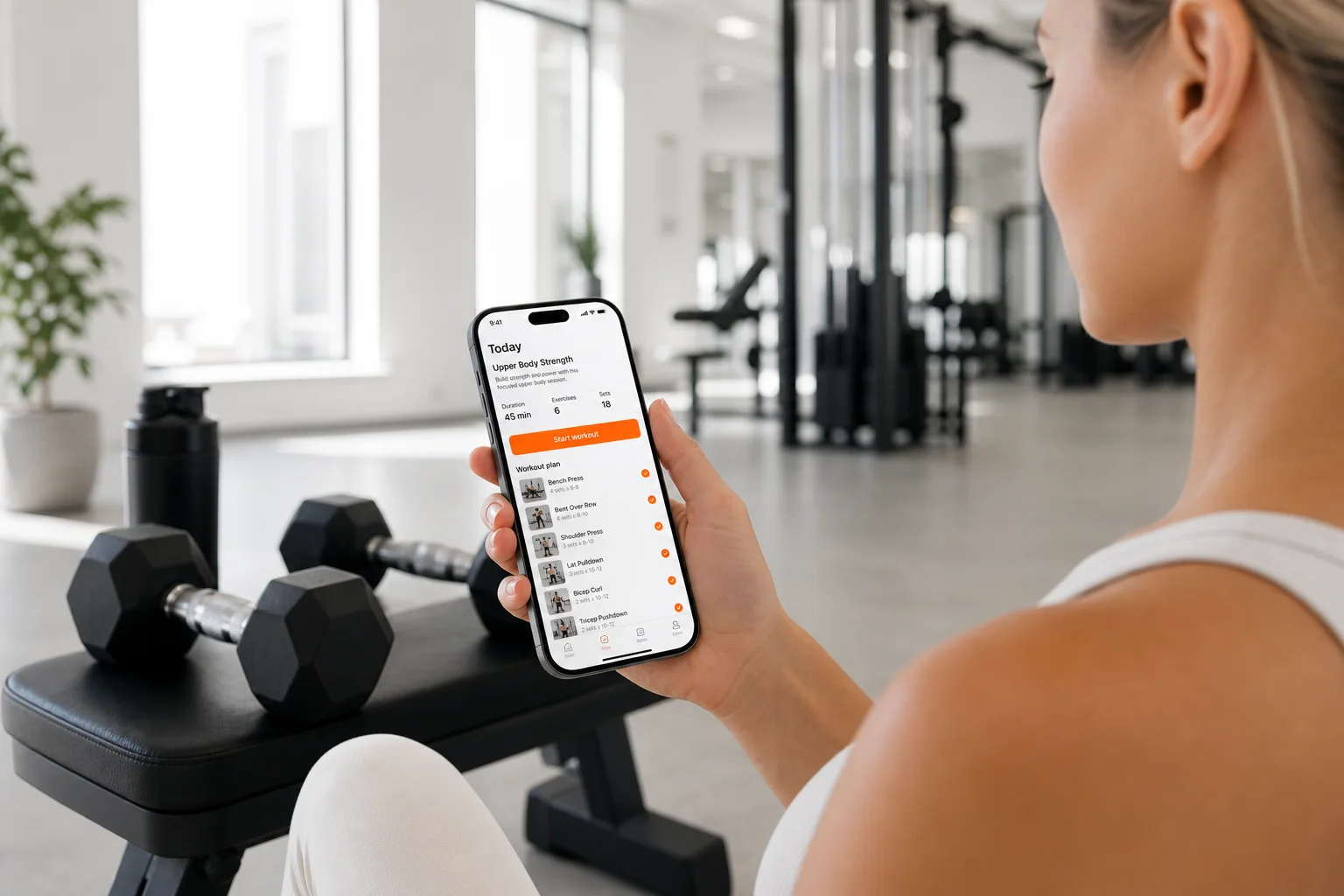 Smartphone con un plan de entrenamiento personalizado de GymPT en un gimnasio moderno